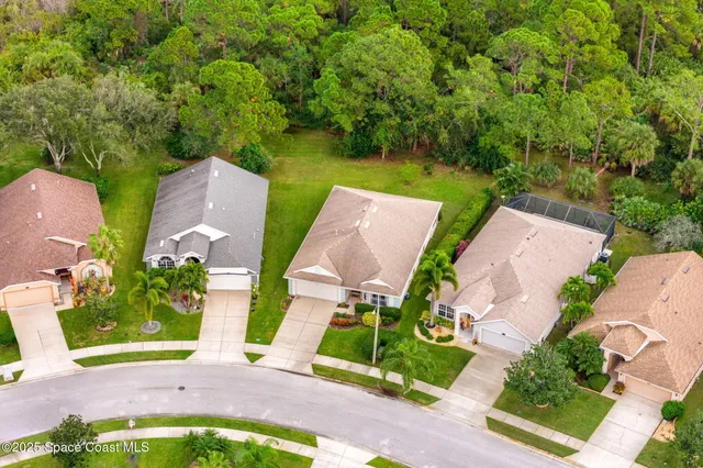 an aerial view of a house with garden space and street view