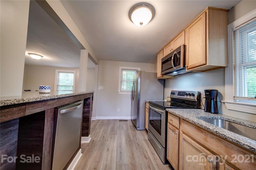 4414 Love Mill Road Monroe, NC 28110 - Photo 14 of 48 a kitchen with stainless steel appliances granite countertop a stove a sink and a microwave