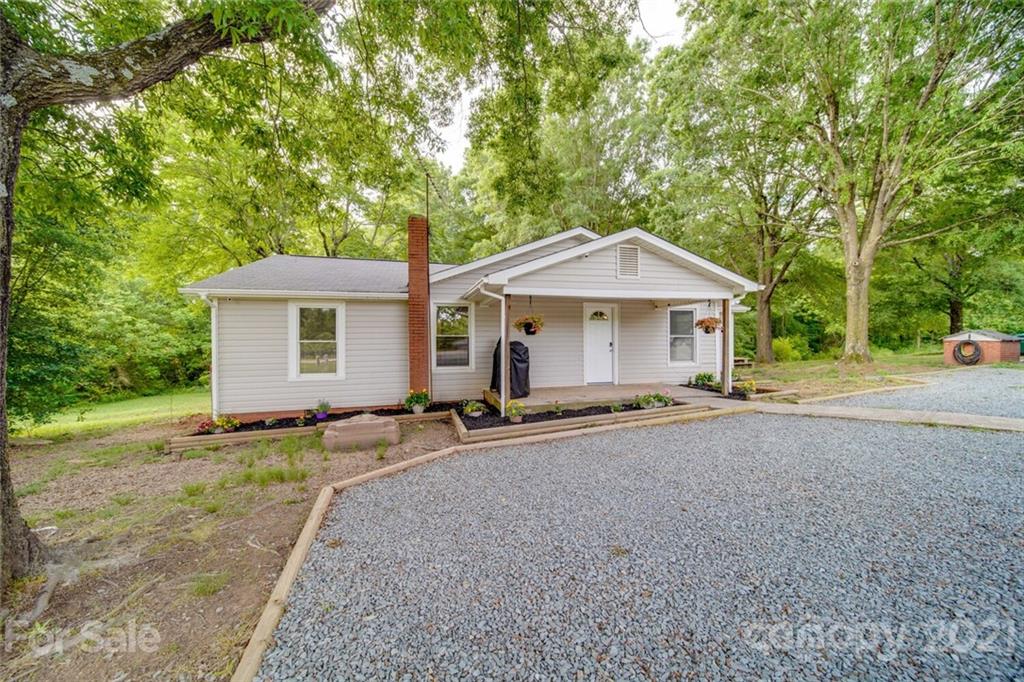 4414 Love Mill Road Monroe, NC 28110 - Photo 10 of 48 a patio with a table and chairs under an umbrella