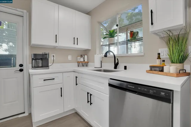 a kitchen with stainless steel appliances granite countertop white cabinets and a stove a oven with white countertops
