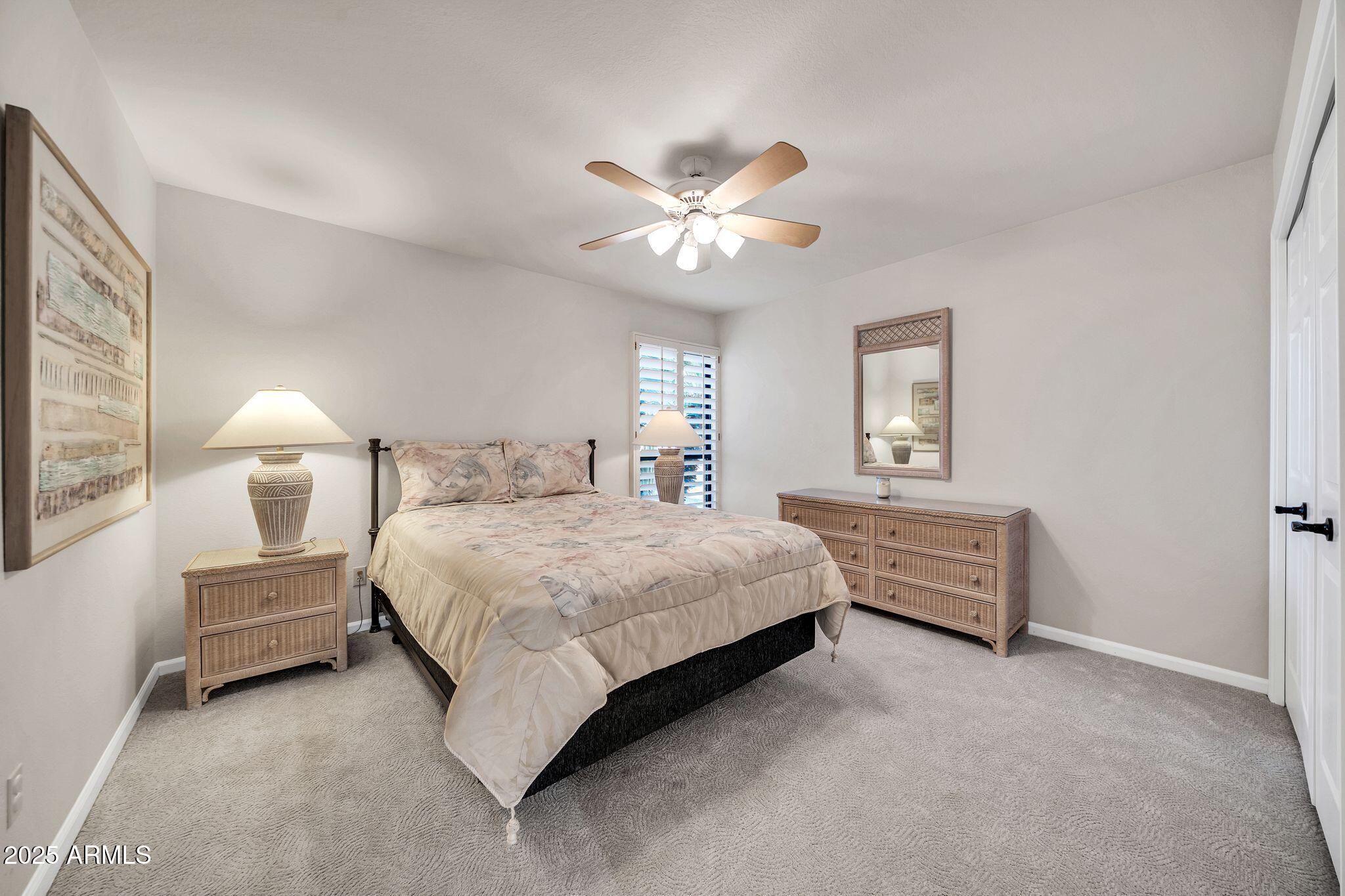 25515 Forest Road, Unit 13 Rio Verde, AZ 85263 - Photo 24 of 37 a bedroom with a bed and a chandelier fan