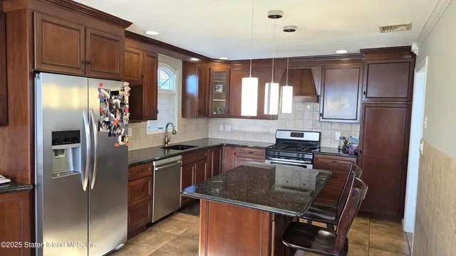 a kitchen with stainless steel appliances granite countertop a refrigerator stove and sink