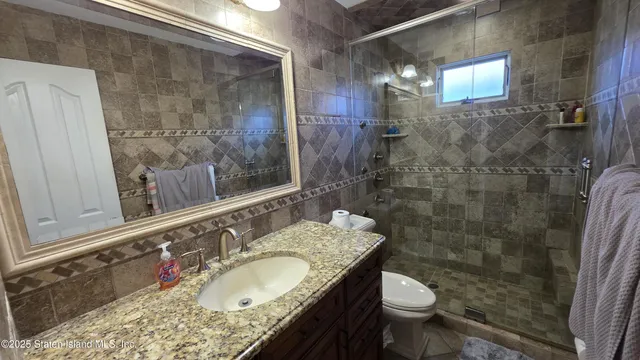 a bathroom with a granite countertop sink toilet and shower