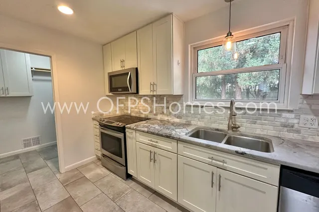 a kitchen with stainless steel appliances granite countertop a sink and a stove