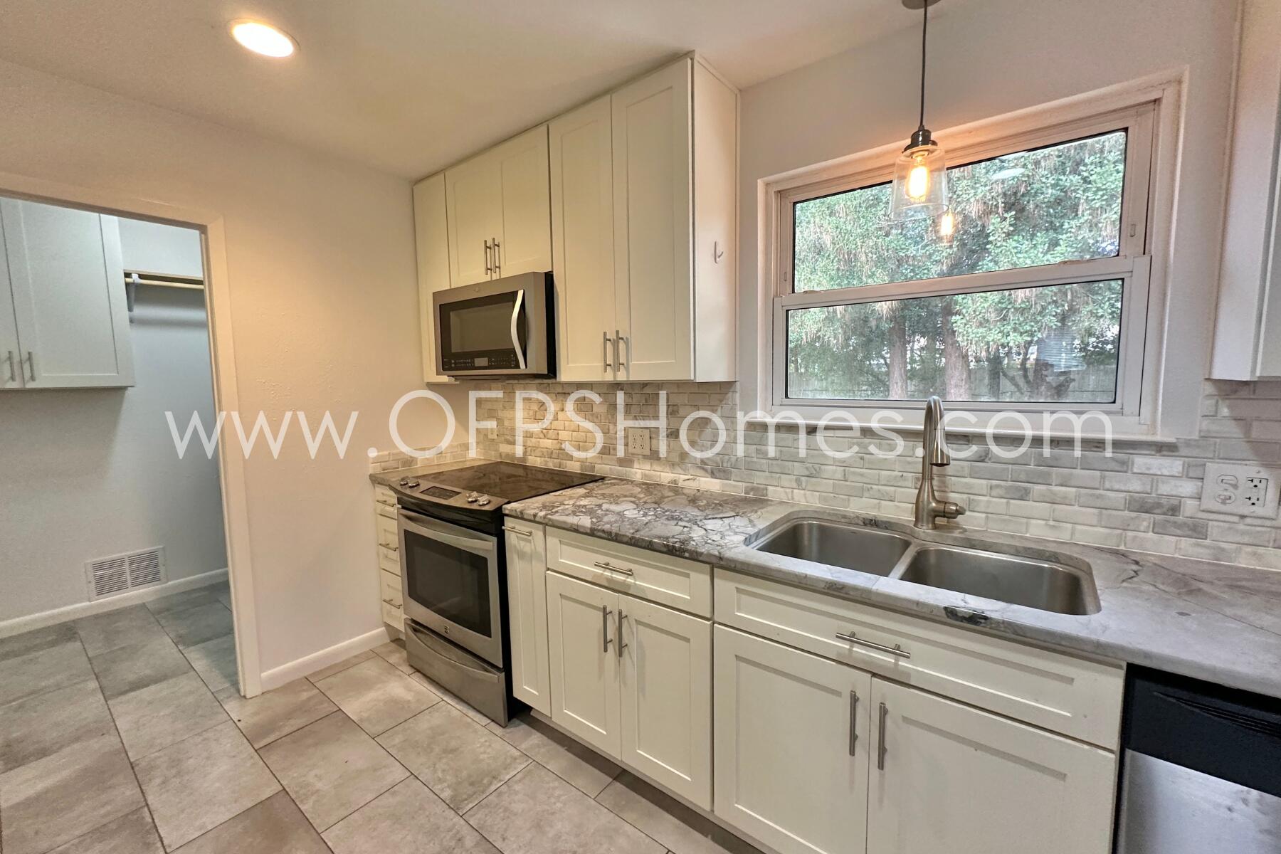 309 Pontevedra Lane Niceville, FL 32578 - Photo 13 of 32 a kitchen with stainless steel appliances granite countertop a sink and a stove