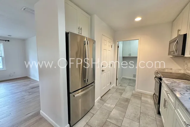 a kitchen with stainless steel appliances granite countertop a refrigerator and a stove