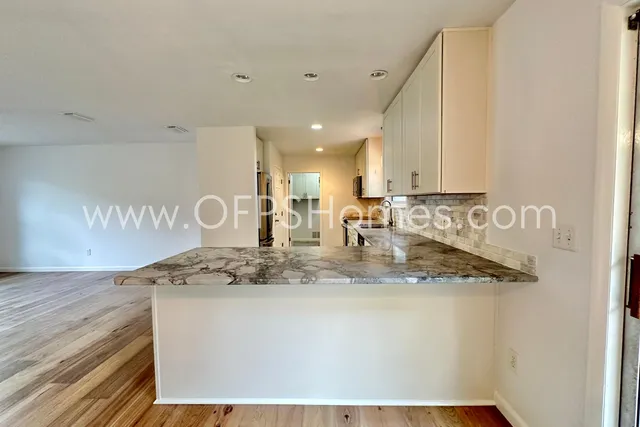 a view of a kitchen counter space a stove and wooden floor