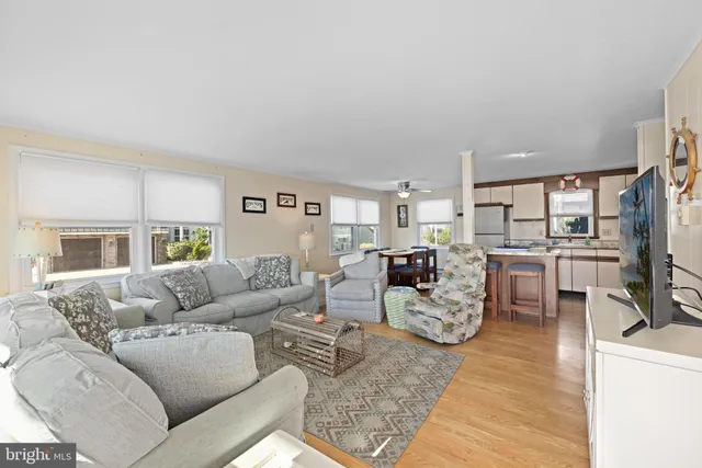 a living room with furniture kitchen view and a large window