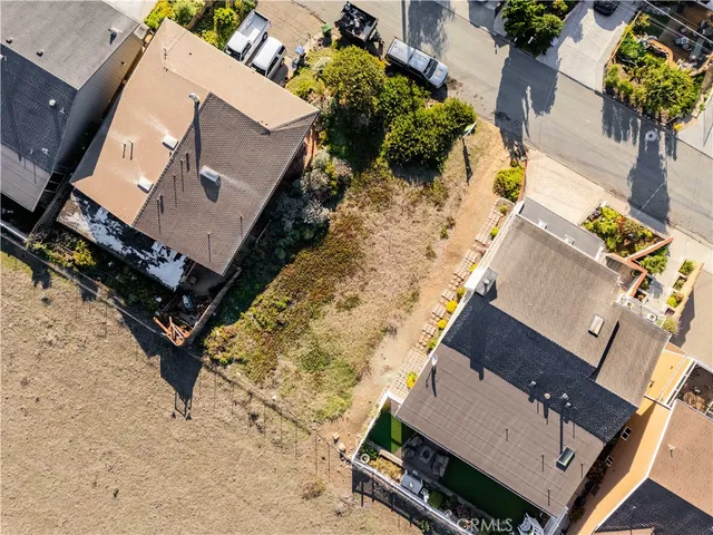 an aerial view of a house with a yard and wooden deck