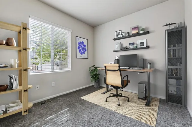 a view of a workspace with furniture and a window