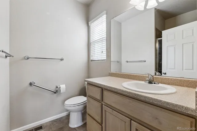 a bathroom with a sink a toilet and a mirror