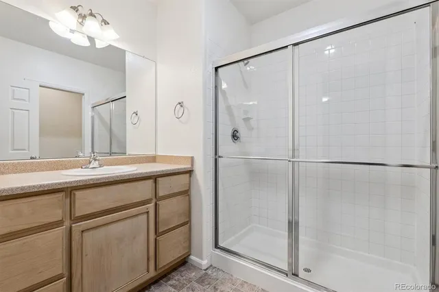 a bathroom with a shower sink and mirror