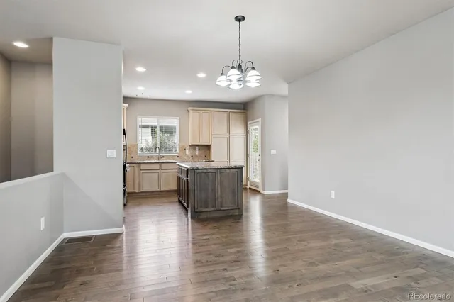 a view of a kitchen with a sink and dishwasher a refrigerator with wooden floor