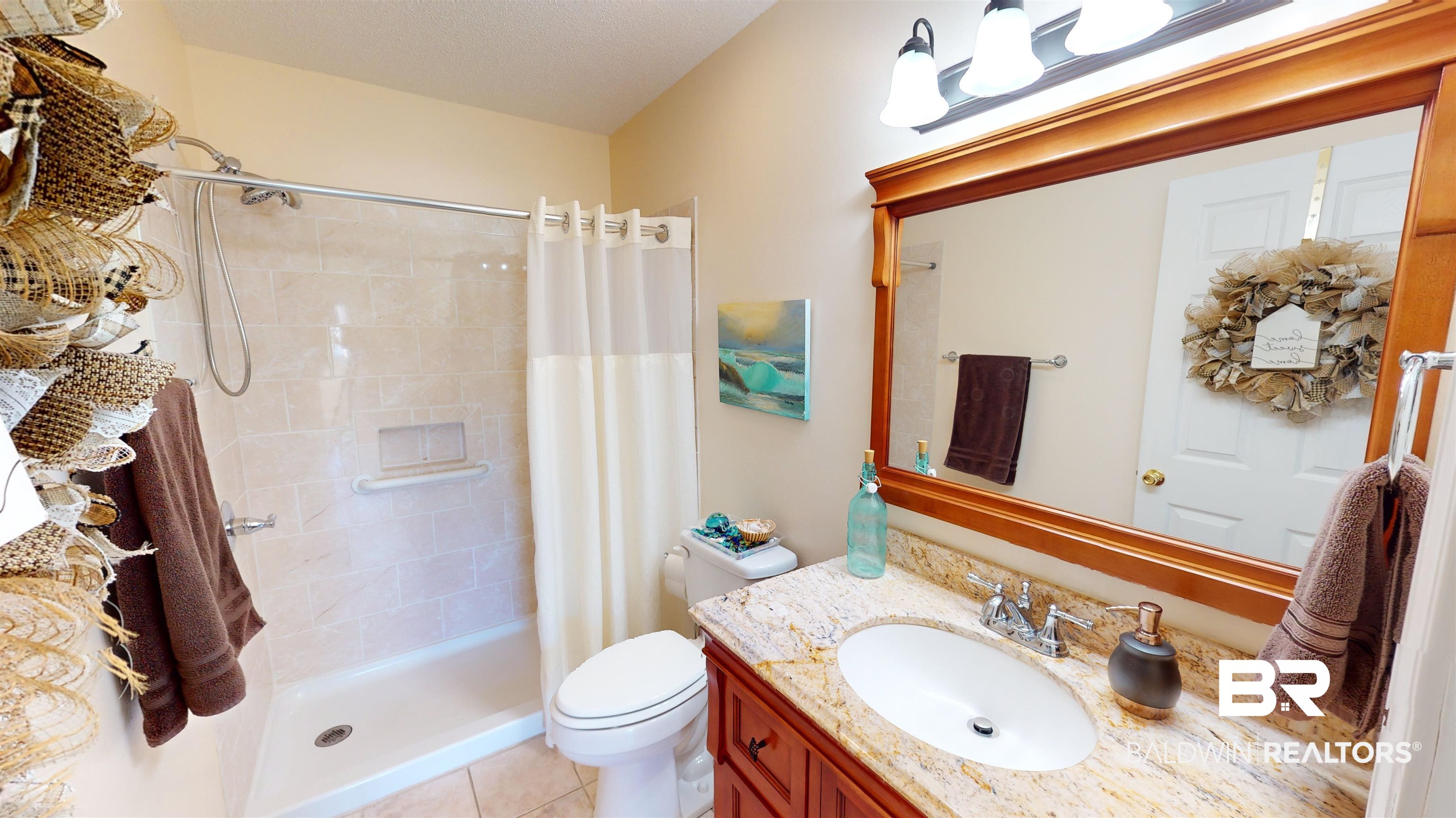 9445 Villas Drive Foley, AL 36535 - Photo 14 of 20 Bathroom featuring walk in shower, tile patterned floors, vanity, and toilet