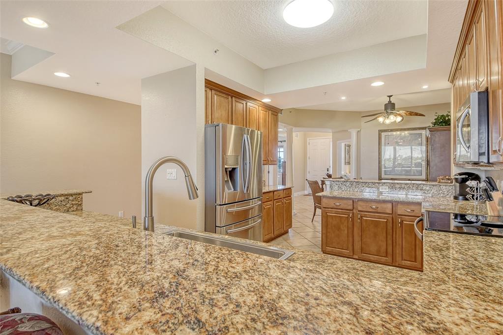 5100 Jessie Harbor Drive, Unit 504 Osprey, FL 34229 - Photo 22 of 87 a large kitchen with kitchen island a sink granite counter tops and a stove