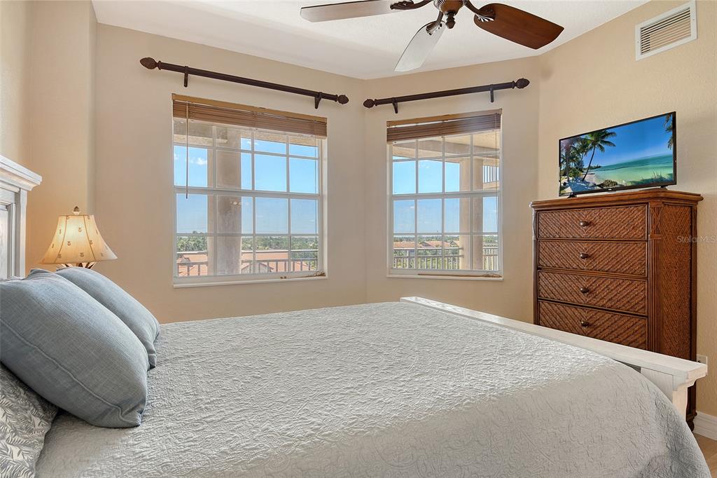 5100 Jessie Harbor Drive, Unit 504 Osprey, FL 34229 - Photo 42 of 87 a bedroom with a bed and a flat tv screen on dresser