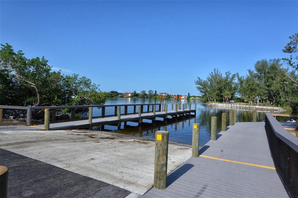 5100 Jessie Harbor Drive, Unit 504 Osprey, FL 34229 - Photo 55 of 87 a view of a lake with boats and wooden bridge