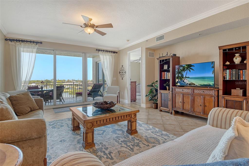 5100 Jessie Harbor Drive, Unit 504 Osprey, FL 34229 - Photo 9 of 87 a living room with furniture and a flat screen tv