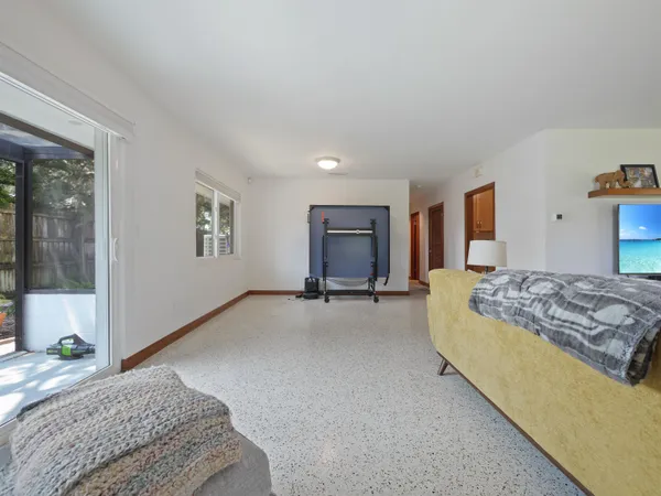 a living room with a bed furniture and next to a window