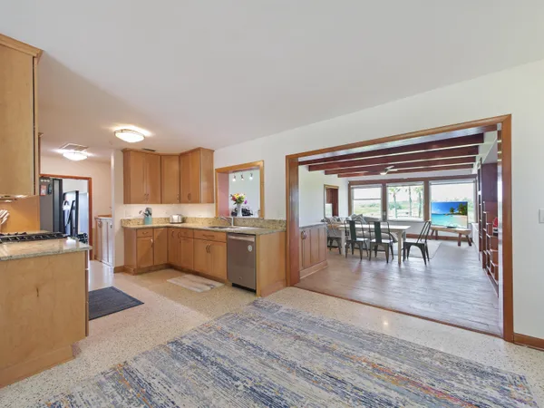 a large white kitchen with lots of counter top space and stainless steel appliances