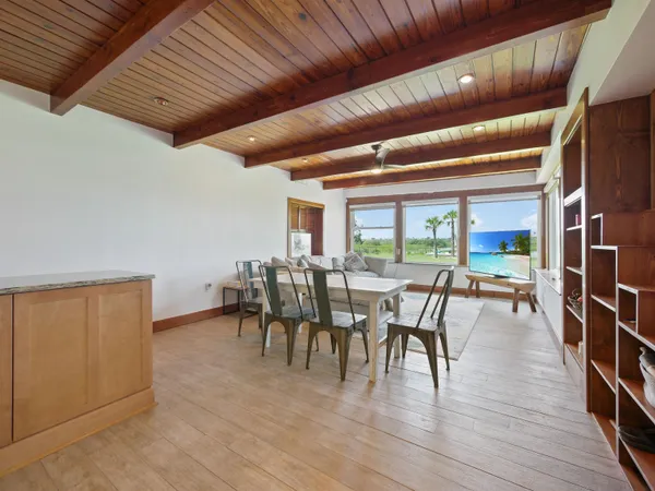 a dining room with furniture floor to ceiling window and wooden floor