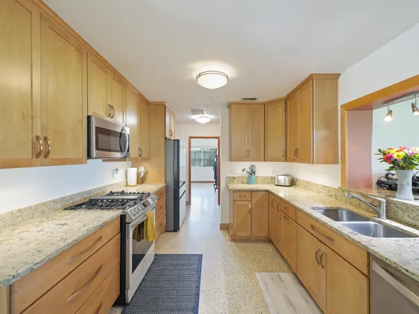 a kitchen with stainless steel appliances granite countertop a sink stove and refrigerator