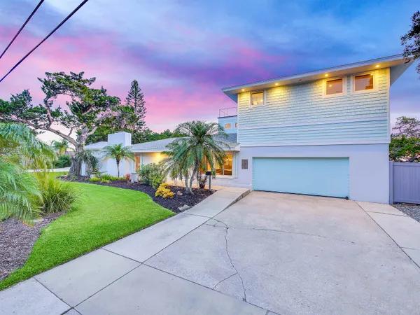 a front view of a house with a yard and potted plants
