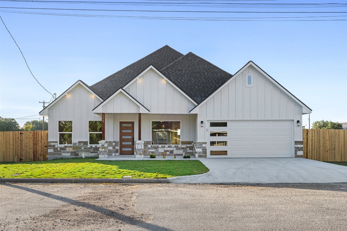Modern inspired farmhouse with board and batten siding, roof with shingles, concrete driveway, and stone siding