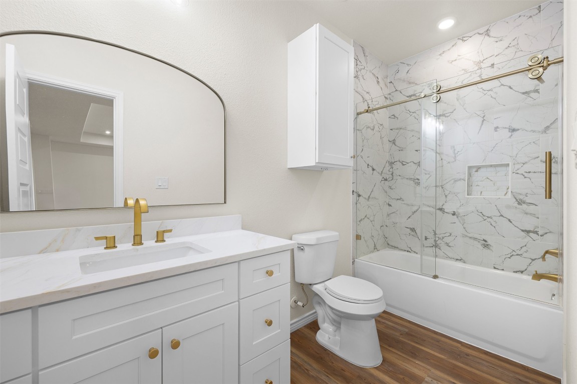 340 Cactus Street Giddings, TX 78942 - Photo 17 of 37 Bathroom featuring combined bath / shower with glass door, dark wood-style floors, vanity, and recessed lighting