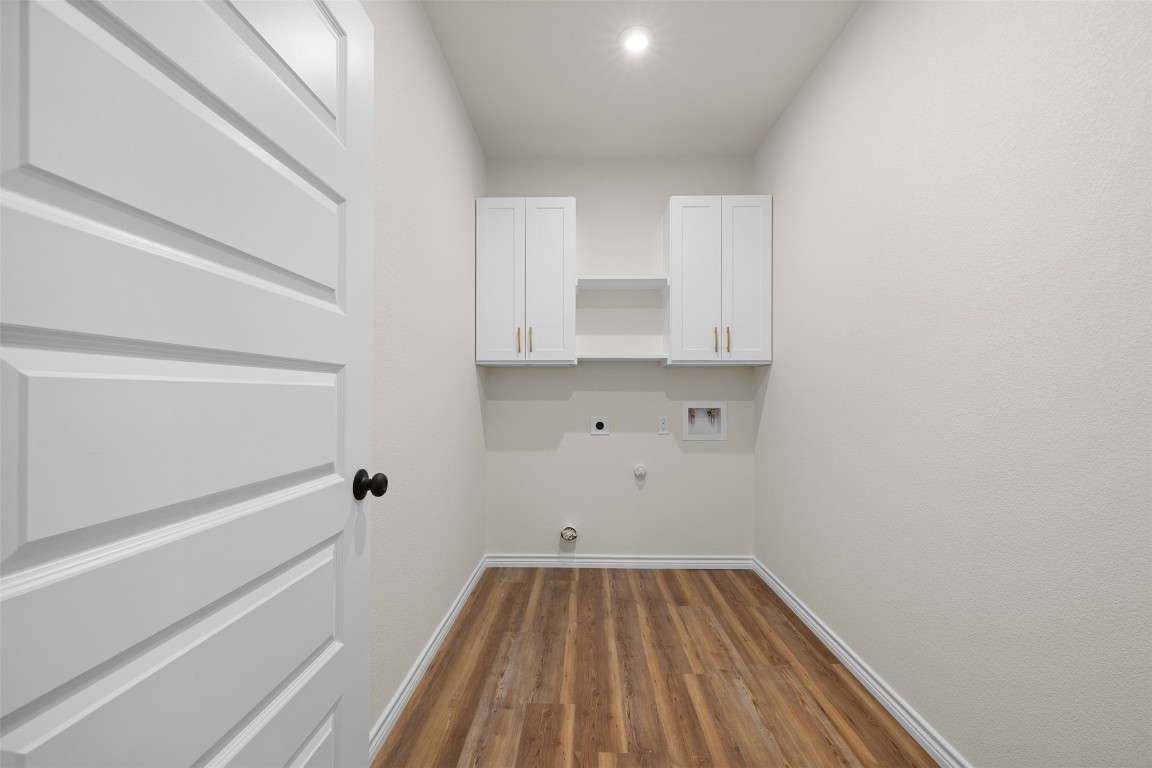 340 Cactus Street Giddings, TX 78942 - Photo 19 of 37 Laundry area featuring dark wood-style floors, hookup for a gas dryer, cabinet space, electric dryer hookup, and washer hookup