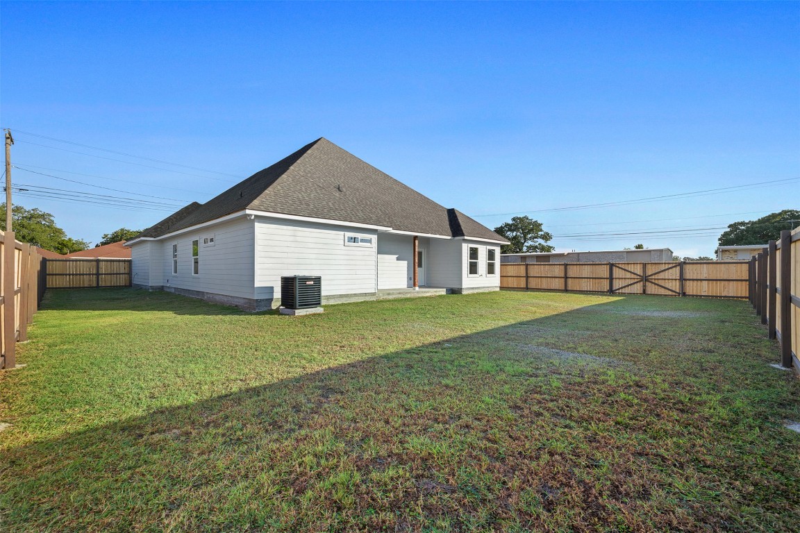 340 Cactus Street Giddings, TX 78942 - Photo 7 of 37 Back of house with a fenced backyard, a patio area, and roof with shingles