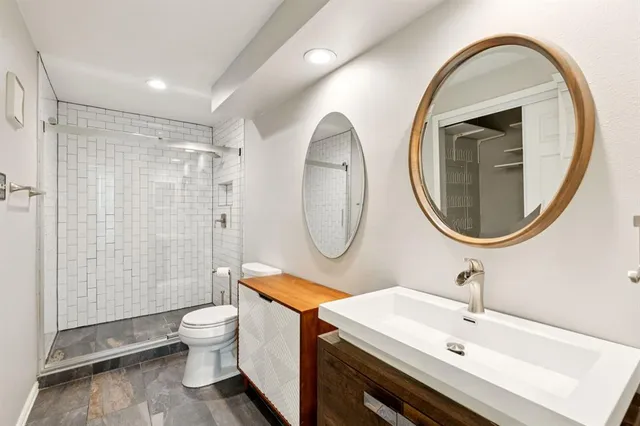 a bathroom with a toilet a sink and a mirror