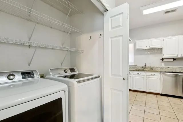 a utility room with cabinets washer and dryer