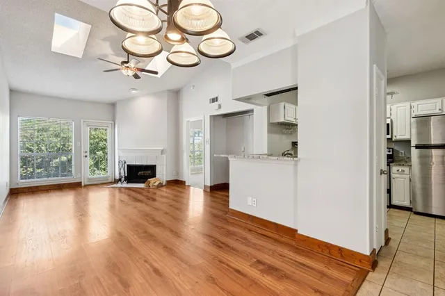 a view of empty room with wooden floor and fireplace