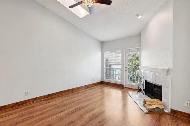 a view of empty room with fireplace and wooden floor