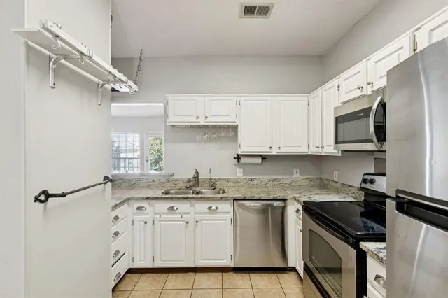 a kitchen with stainless steel appliances granite countertop a sink a stove a microwave and cabinets