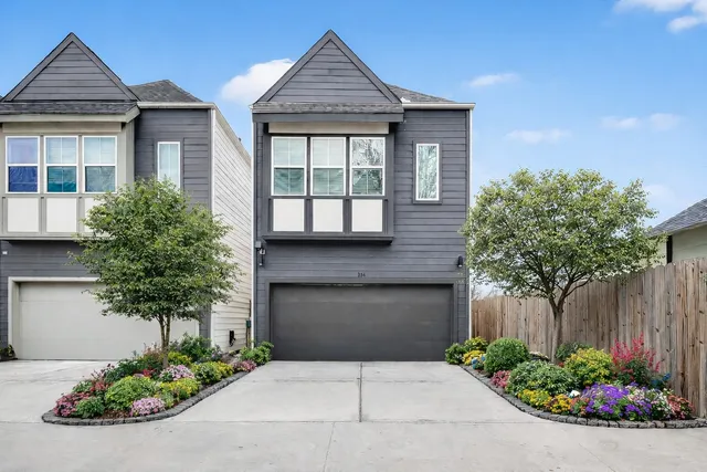 a front view of a house with a yard and potted plants