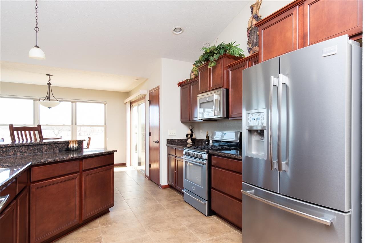 6350 Blomberg Road Cherry Valley, IL 61016 - Photo 4 of 25 a kitchen with granite countertop stainless steel appliances and wooden cabinets