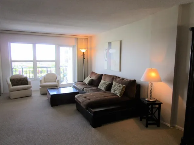 a living room with furniture and large windows