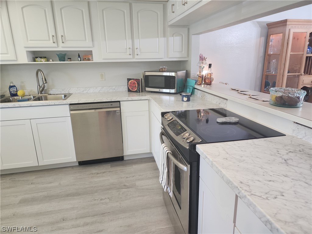 16560 Partridge Place Road, Unit 102 Fort Myers, FL 33908 - Photo 18 of 18 a kitchen with stainless steel appliances granite countertop a sink stove and refrigerator