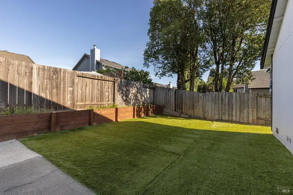 a view of a backyard with wooden fence