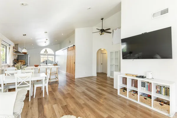 a living room with stainless steel appliances furniture and a flat screen tv