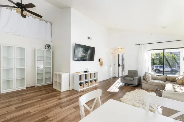 a living room with furniture large window and wooden floor