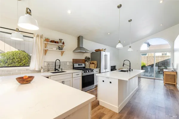 a kitchen with a sink a stove and chairs