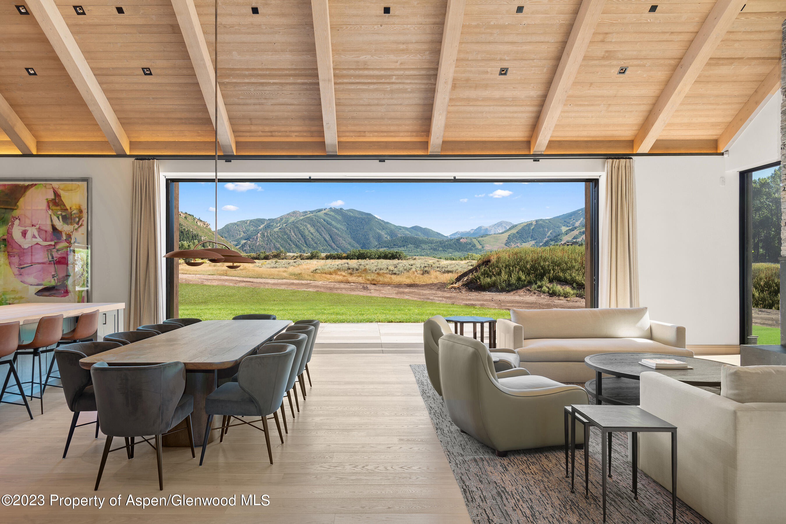 245 Slalom Path Aspen, CO 81612 - Photo 12 of 34 a view of a dining room with furniture one side kitchen view and wooden floor
