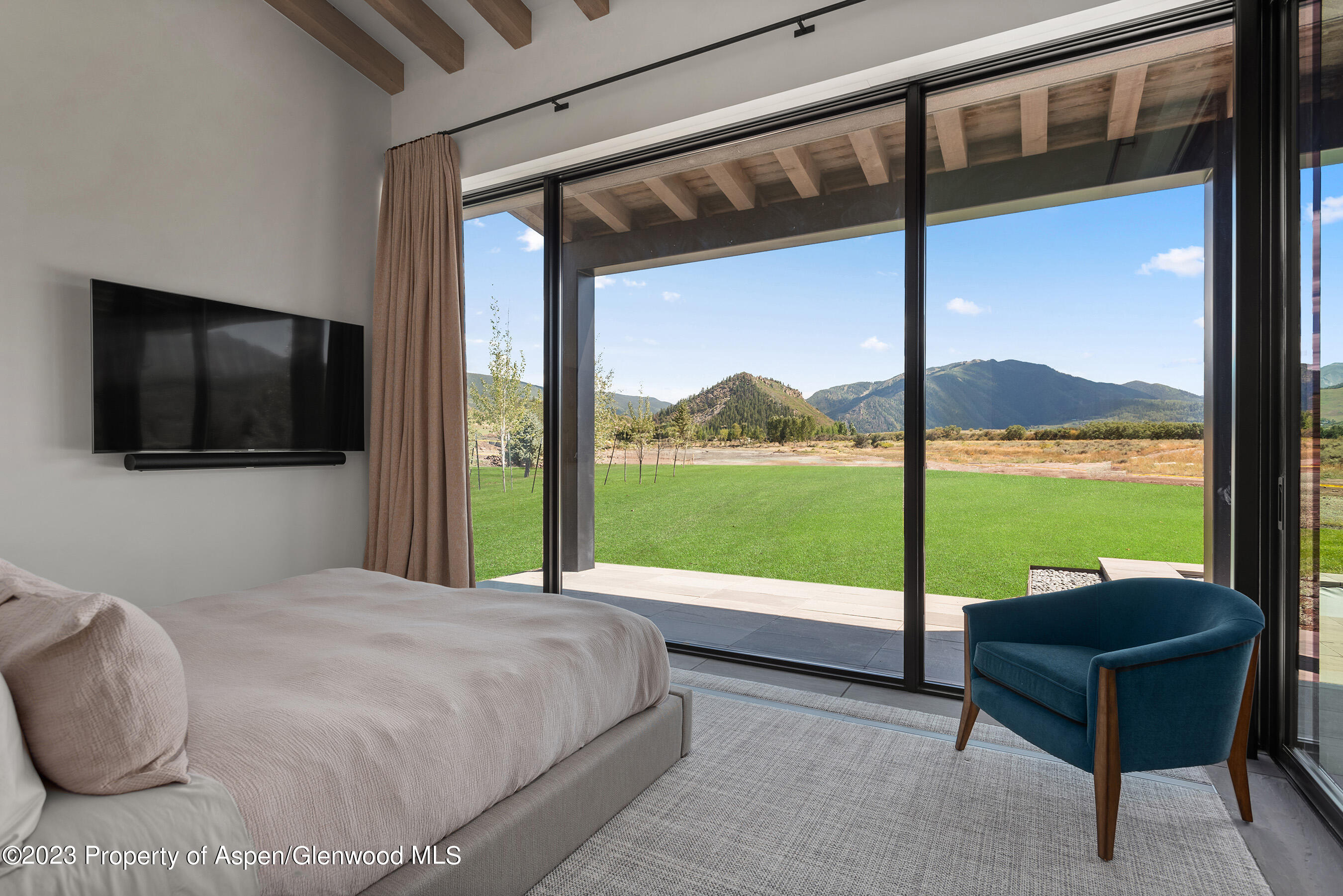 245 Slalom Path Aspen, CO 81612 - Photo 23 of 34 a living room with a large window and a flat screen tv