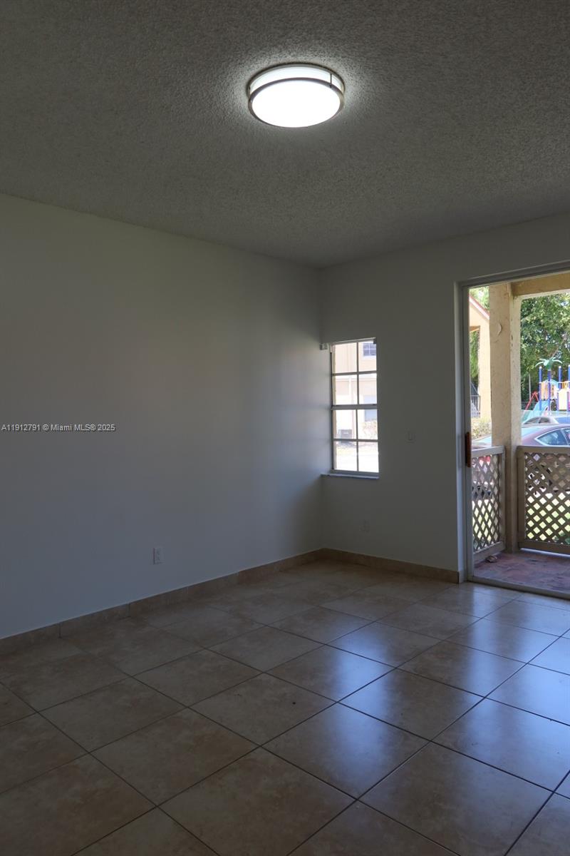 18340 Northwest 68th Avenue, Unit A Hialeah, FL 33015 - Photo 4 of 10 an empty room with windows