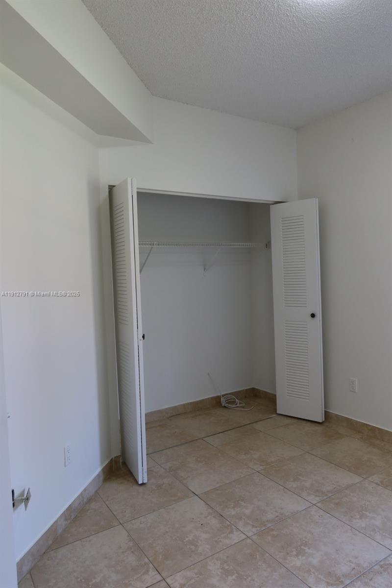 18340 Northwest 68th Avenue, Unit A Hialeah, FL 33015 - Photo 9 of 10 an empty room with closet area