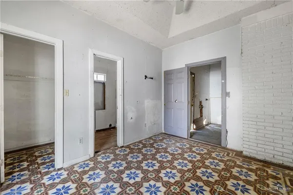 an empty room with windows and closet