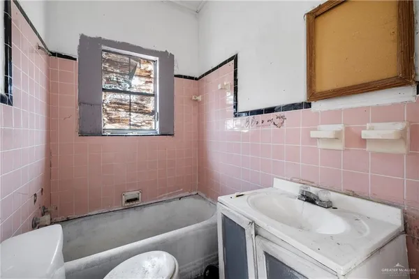 a bathroom with a granite countertop toilet sink tub and mirror